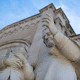 Ci avviciniamo al prospetto color panna realizzato a mosaico e sorvegliato ai lati da due statue raffiguranti Don Bosco...